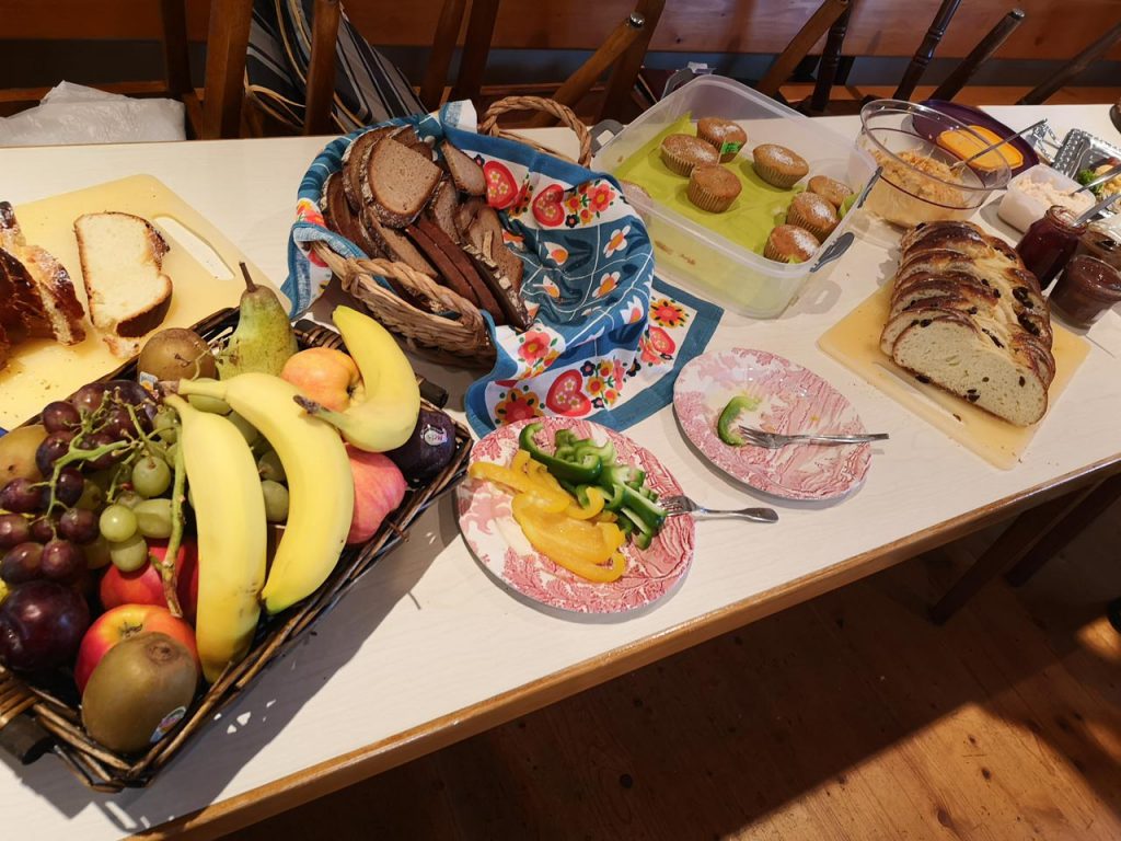 Eine gedeckte Frühstückstafel mit Obst, Kuchen und Brot 