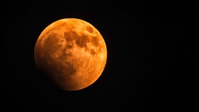 Symbolbild eines großen roten Mondes am schwarzen Nachthimmel