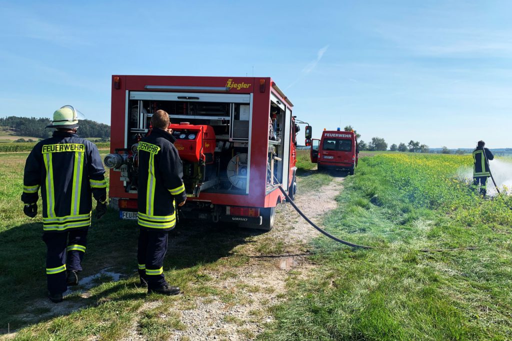 Brand Freifläche zwischen Ungetsheim und Bergnerzell - Feuerwehrmann steht am TSF-W