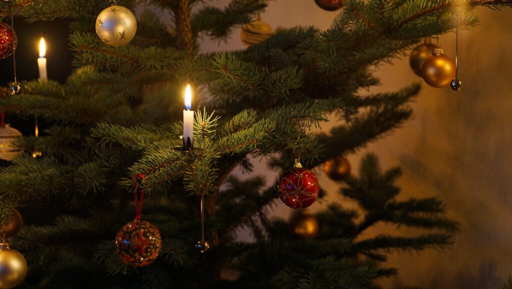 Ein Weihnachtsbaum mit Kerzen im dunklen Zimmer