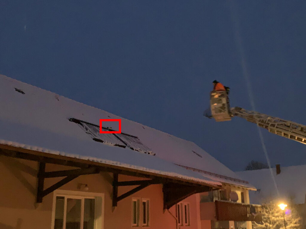 Drehleiter steuert auf Dach mit Schnee zu - klein die Katze im Bild